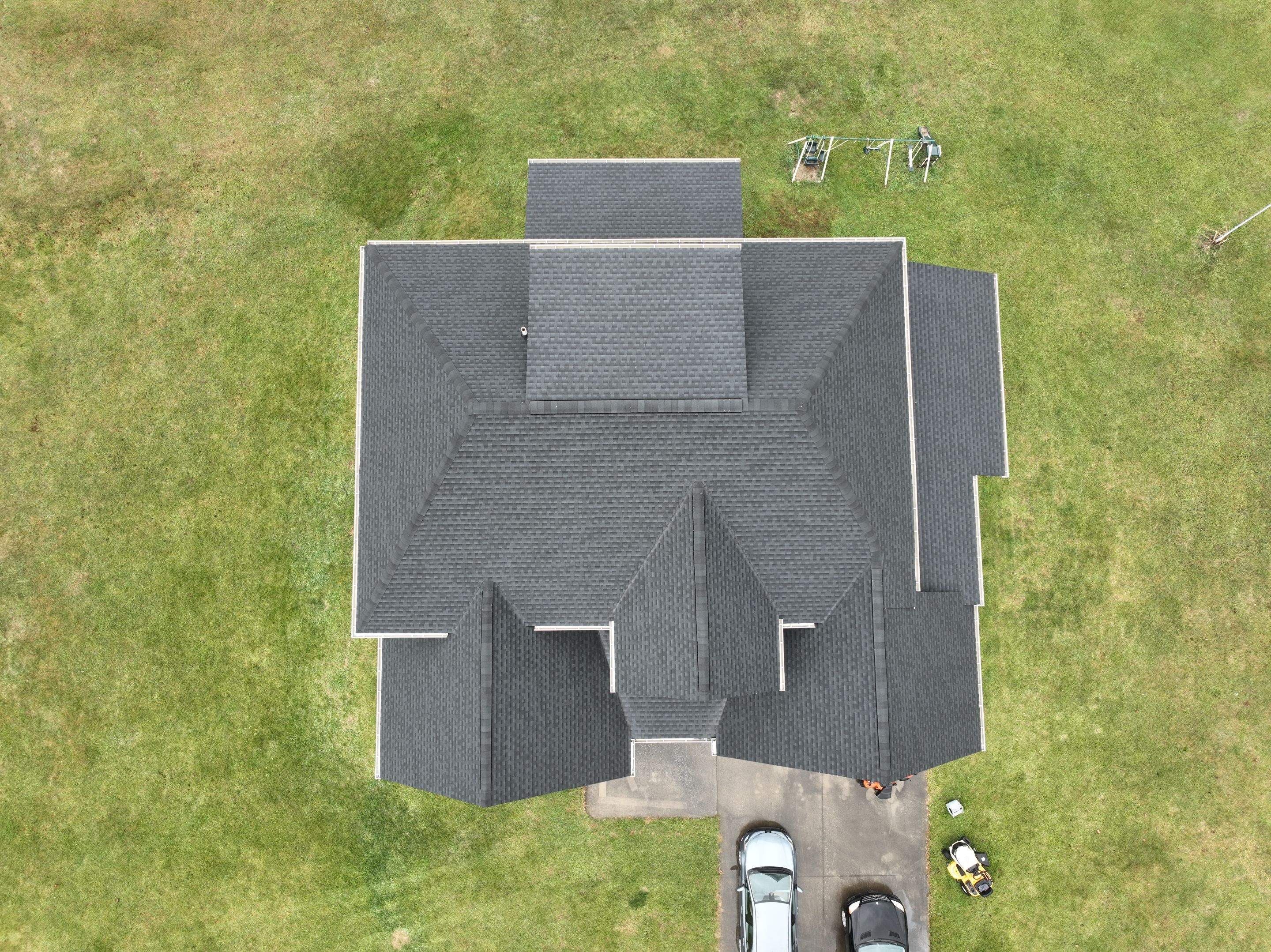 Top-down aerial of a completed charcoal shingle roof